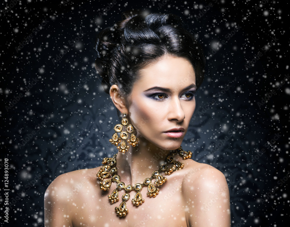 Portrait of a young woman in jewelry on snow