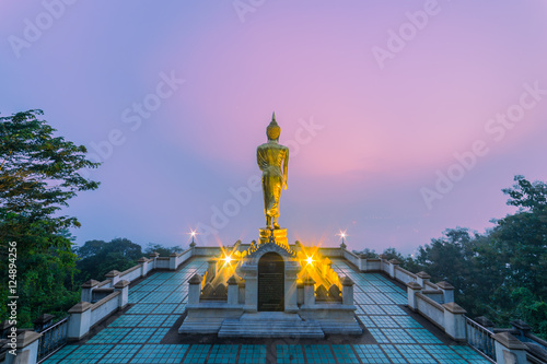 Sunrise scence of Golden Buddha statue standing on a mountain Wat Phra That Khao Noi, Nan Province, Thailand