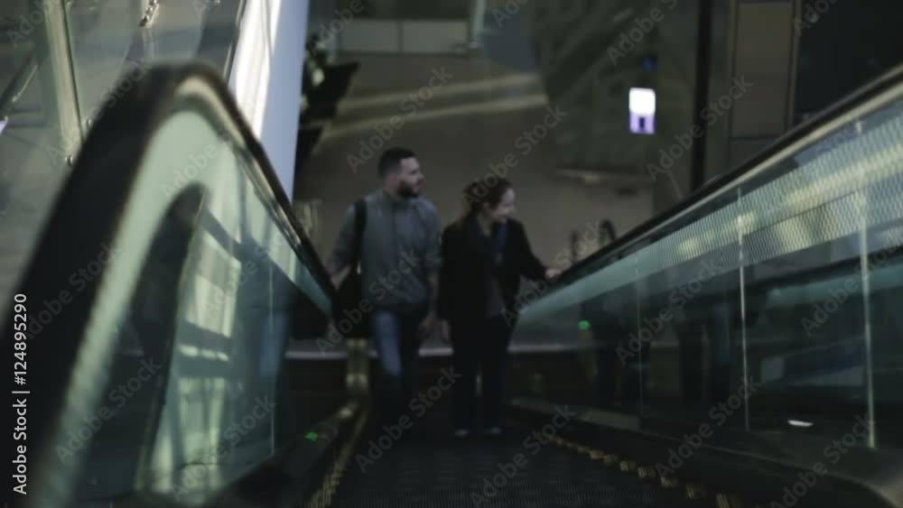 A pair of lovers of tourists rises on the escalator on the next floor. A pair of lovers of tourists rises on the escalator on the next floor.