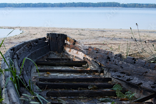 Old abandoned wooden boat on the lake. close-up of the nose of the boat photo