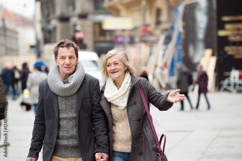 Senior couple on a walk in city centre. Winter
