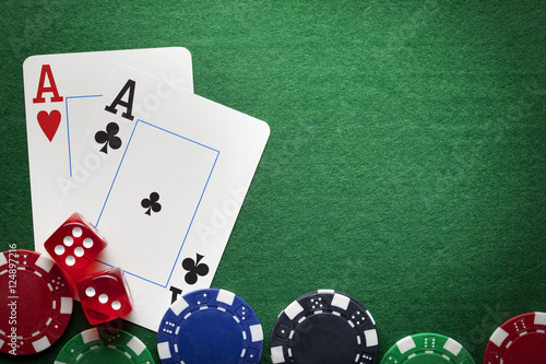 Playing cards, poker chips, and dices on green table