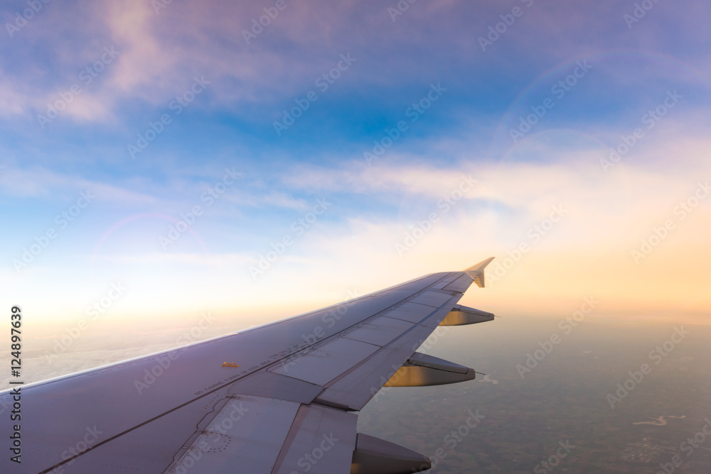 Wing of the airplane on blue and pink sky background at sunset Wing of the airplane on blue and pink sky background at sunset