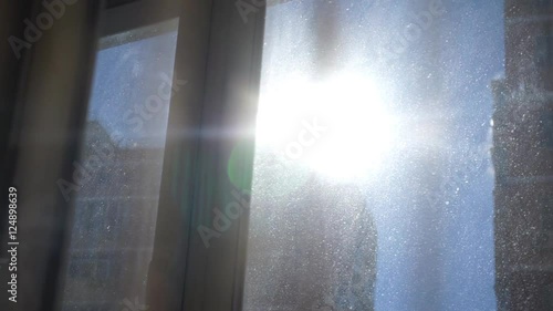 Solar flare through the curtain on a dirty window