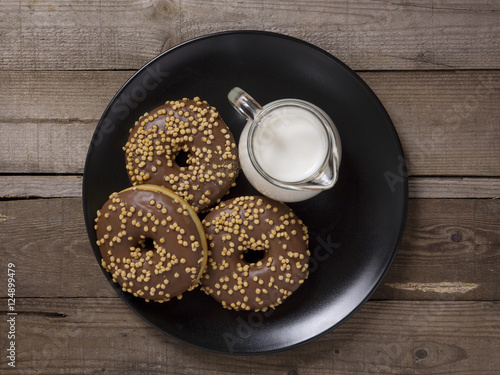 Ciambelle donuts e latte, su piatto nero, dall'alto