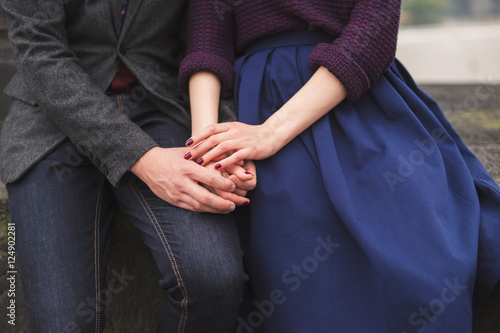 Couple sitting side by side holding hands