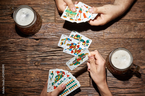 Hände beim Kartenspiel mit Bier