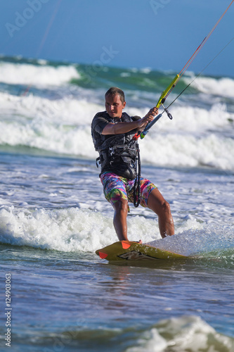Athletic man jump on kite surf board sea waves