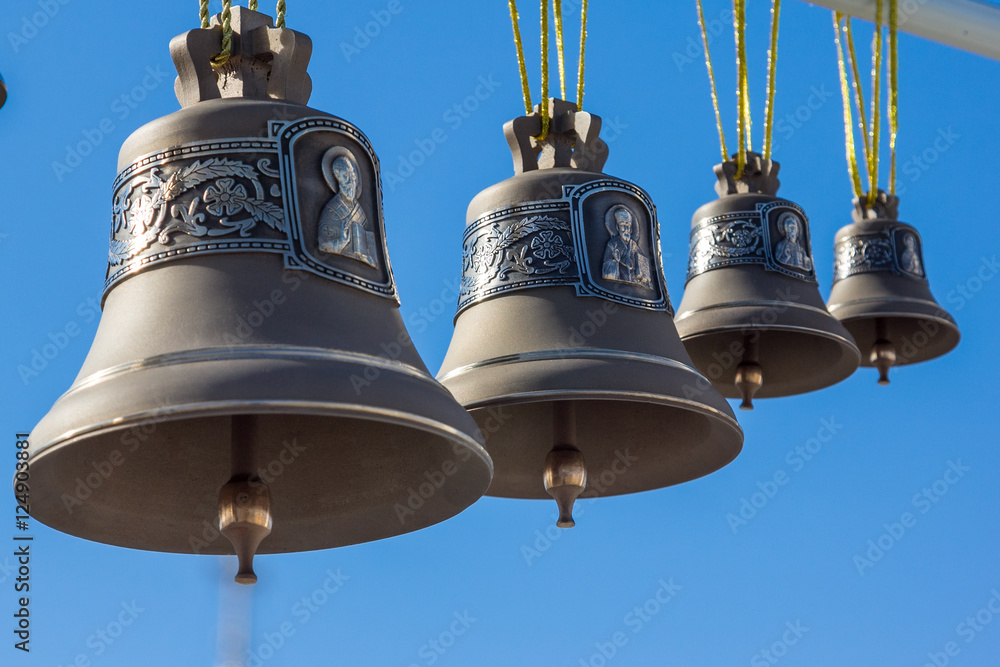 Bronze bells different sizes on a background of the sky