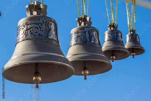 Bronze bells different sizes on a background of the sky photo