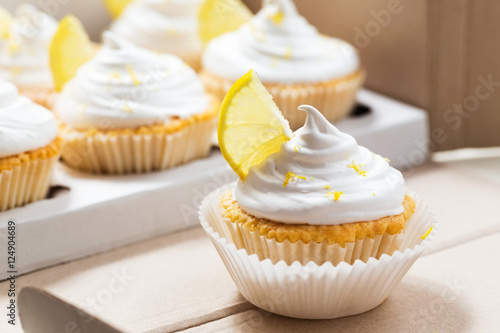 Lemon cupcakes with white cream, cupcake packaging, delivery box, selective focus, close up