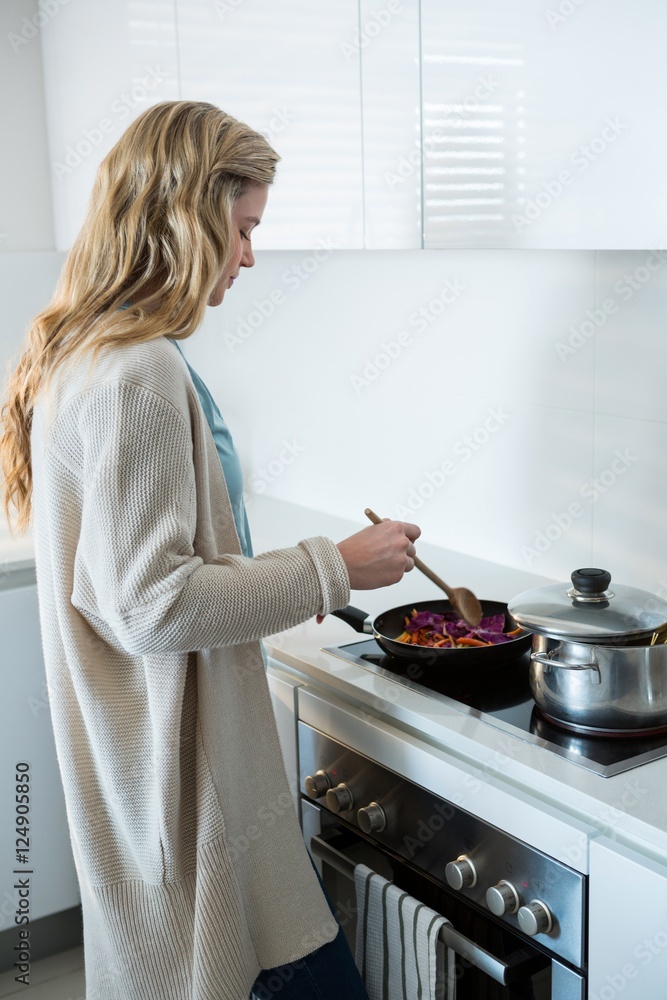 Woman cooking food in kitchen Woman cooking food in kitchen