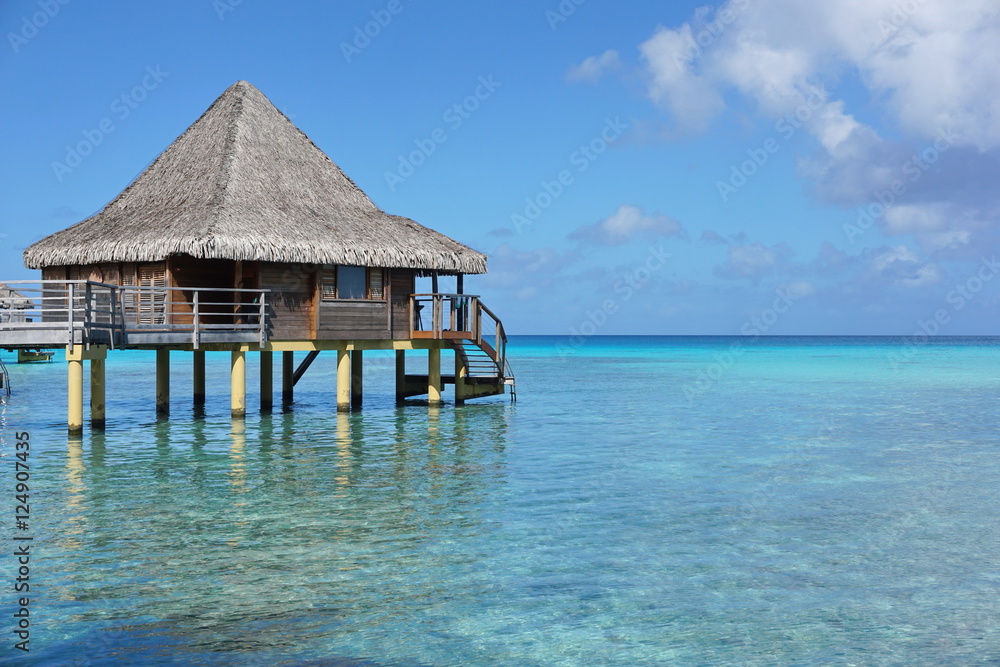 Overwater bungalow with thatched roof in the lagoon of Rangiroa, south Pacific ocean, Tuamotu, French Polynesia
