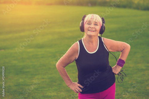 Senior woman in headphones. Smiling person outdoors. First album of favorite band. Songs that inspire.