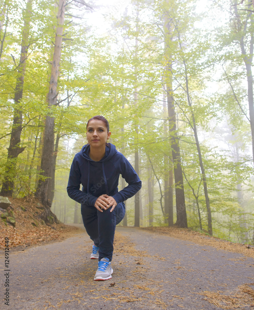 Obraz premium Energetic young woman do exercises outdoors in park to keep their bodies in shape. Fitness concept. Body-building theme. Sport mood.