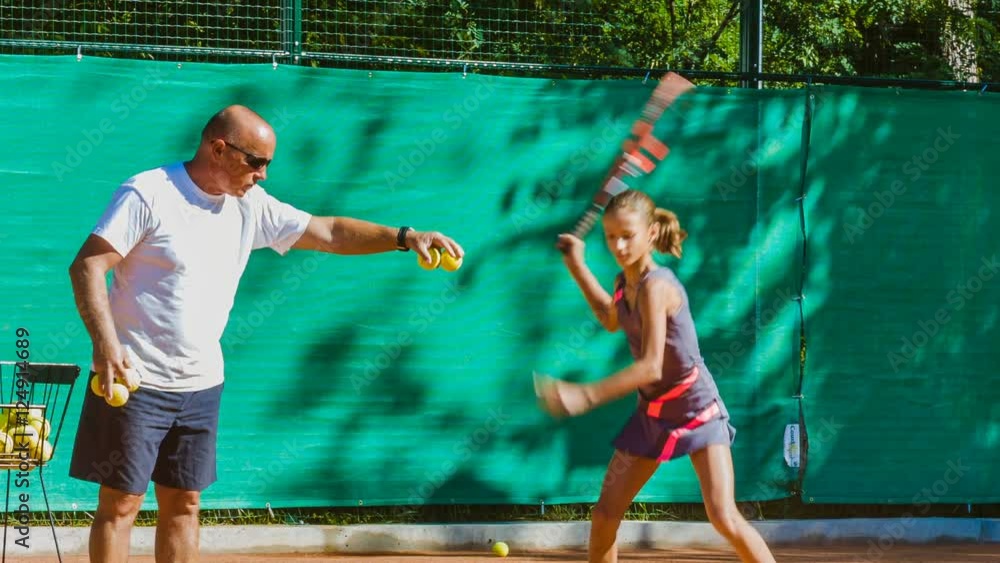 Instructor or coach teaching child how to play tennis on a court indoor Instructor or coach teaching child how to play tennis on a court indoor