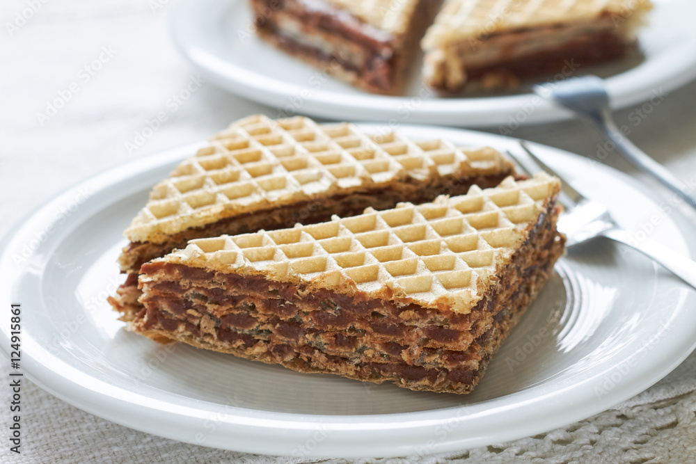 Wafer sheets filled with caramelized sugar and hazelnut cream served on white plate Wafer sheets filled with caramelized sugar and hazelnut cream served on white plate