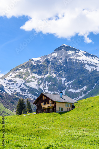 Beautiful Swiss mountain valley landscape with a single house.