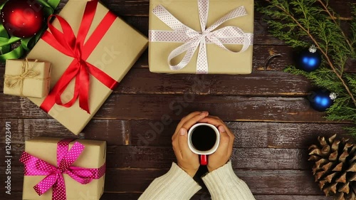 Top view hands drinking coffee christmas presents table from above
