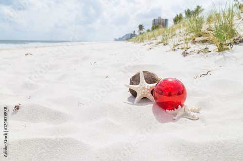 red glass ball and starfish/Christmas ornament and starfish on the tropical beach background.