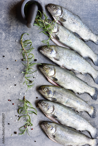 Rainbow trouts on a stone board with herbs