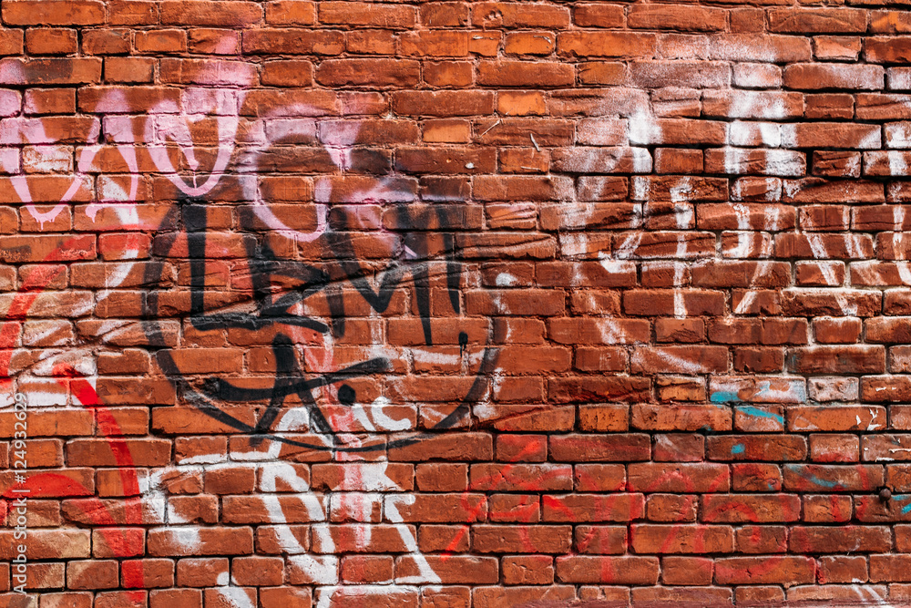 Fototapeta premium red brick wall with graffiti in different colors