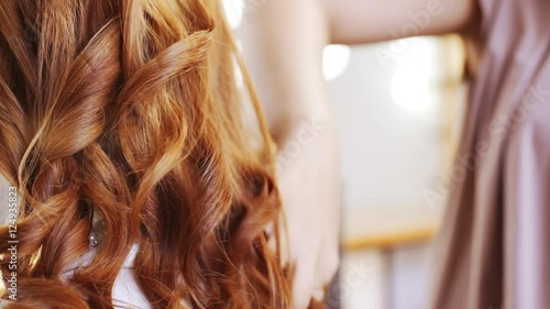 Hairdresser making hairstyle to foxy girl in beauty salon Slow motion Close up