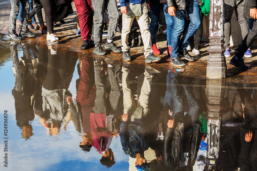 crowd of people reflecting in a puddle