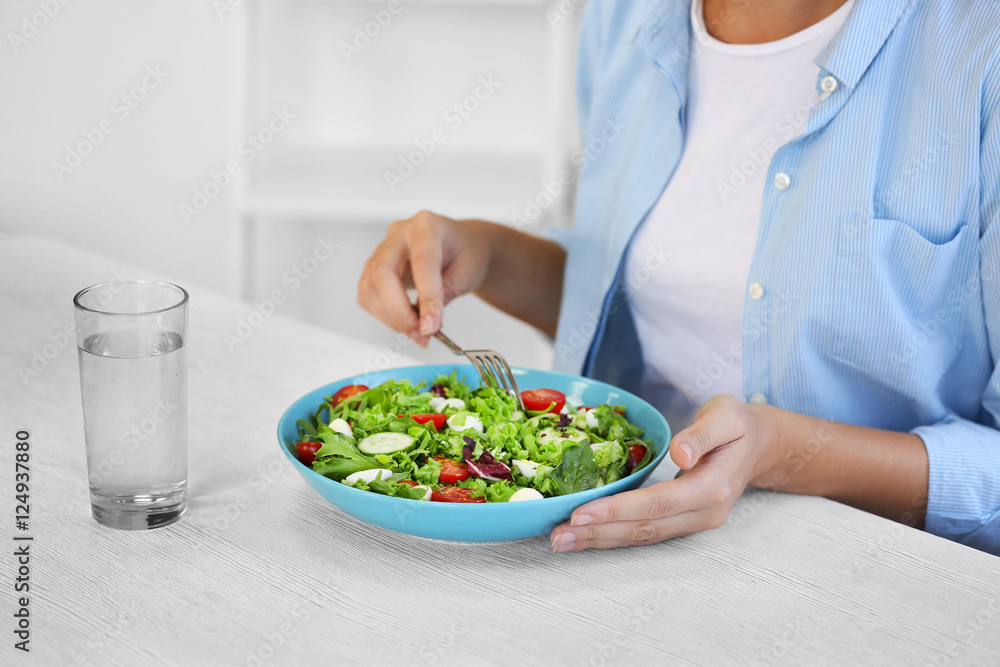 Woman eating fresh delicious salad at table Woman eating fresh delicious salad at table