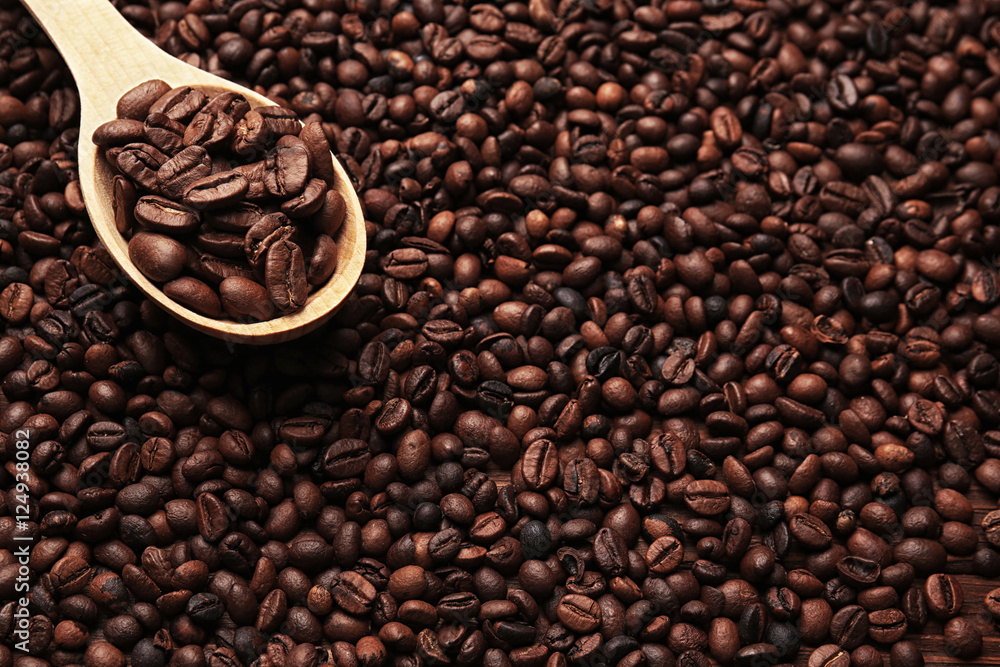 Wooden spoon with roasted coffee beans