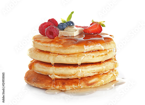 Stack of tasty pancakes with berries and syrup isolated on white