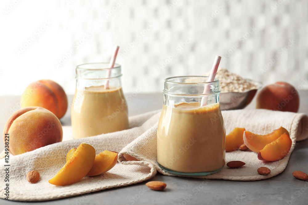 Mason jars with tasty smoothie, some ingredients and napkin on kitchen table Mason jars with tasty smoothie, some ingredients and napkin on kitchen table