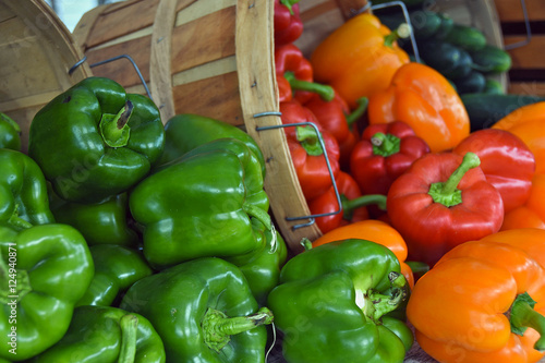 variety of peppers tumbling out of bushel baskets at the market