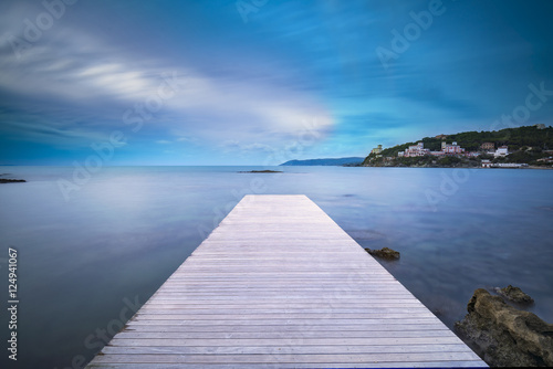 Fototapeta Naklejka Na Ścianę i Meble -  Castiglioncello bay wooden pier, rocks and sea on sunset. Italy