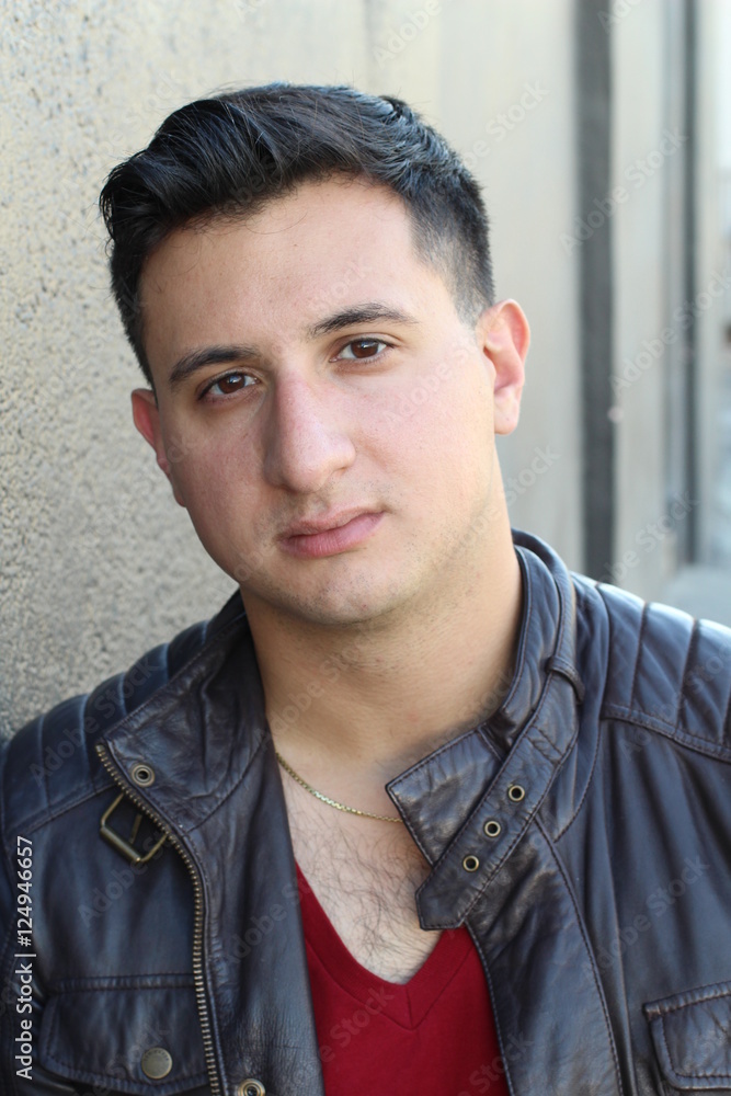 Fototapeta premium Portrait of a handsome young man with neutral expression at camera, isolated on gray