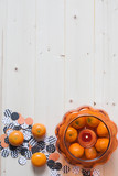 Light wooden background  with Halloween decoration: clementines and a garland. Copy space. 