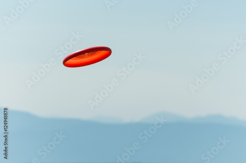 Frisbee flying through the air with a view of the mountains in the distance