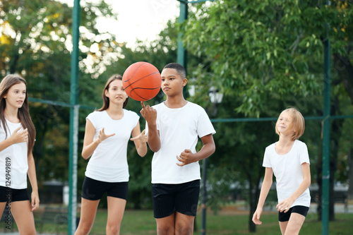 Teenagers playing basketball on school yard