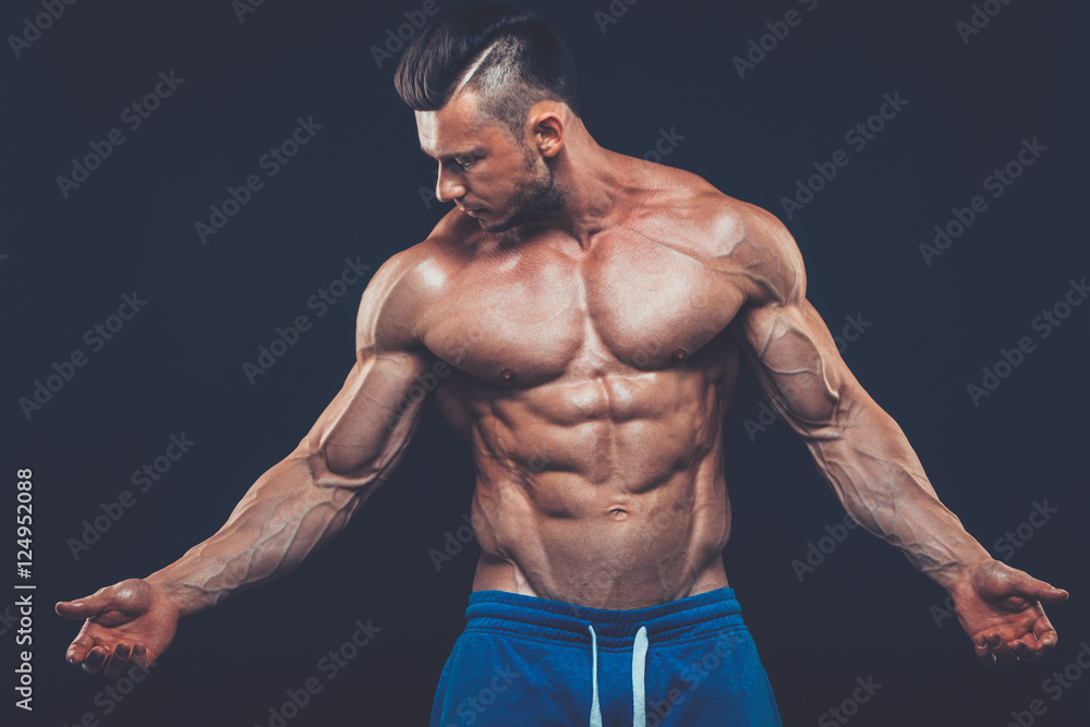 Fototapeta premium strong athletic man on black background