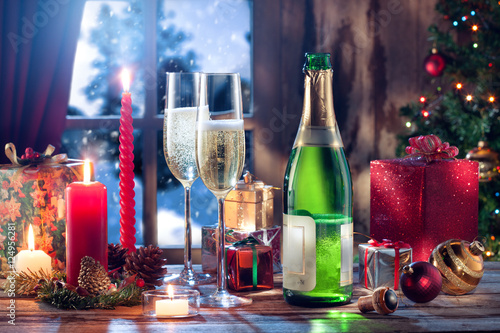 close up view of champagne with candles and gifts on color back