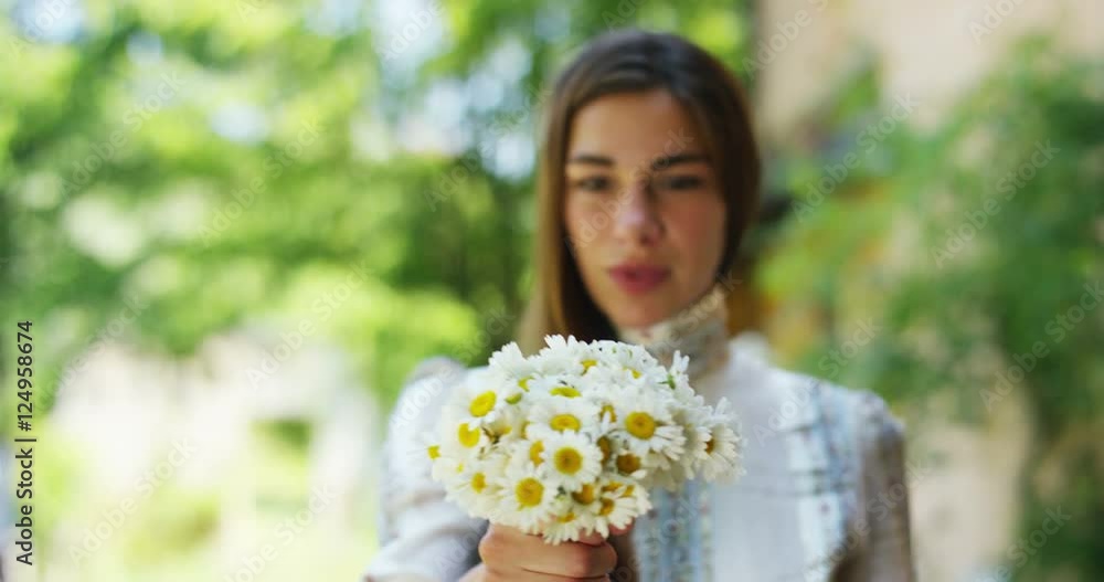A woman surrounded by greenery has collected flowers and count them in thought, thinking about his love thinks of his life that he spends. flowers that bring back memories of the good memories. A woman surrounded by greenery has collected flowers and count them in thought, thinking about his love thinks of his life that he spends. flowers that bring back memories of the good memories.
