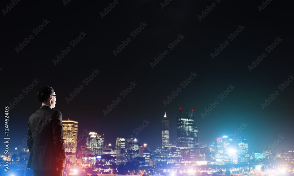 Businessman viewing night glowing city Businessman viewing night glowing city