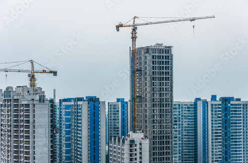 View Of Cranes against skyline with cityscape.