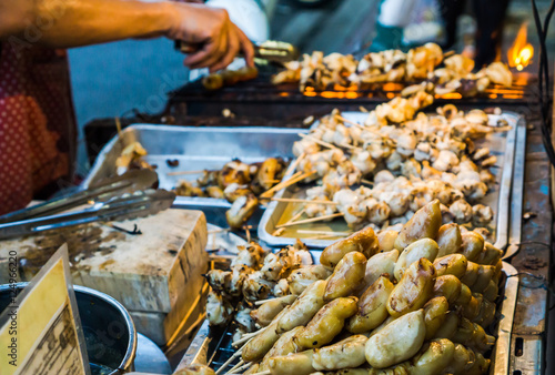 Evening street food in Bangkok, Thailand : Grilled squid on gridiron in evening street market, Squid barbecue in Thai street food market