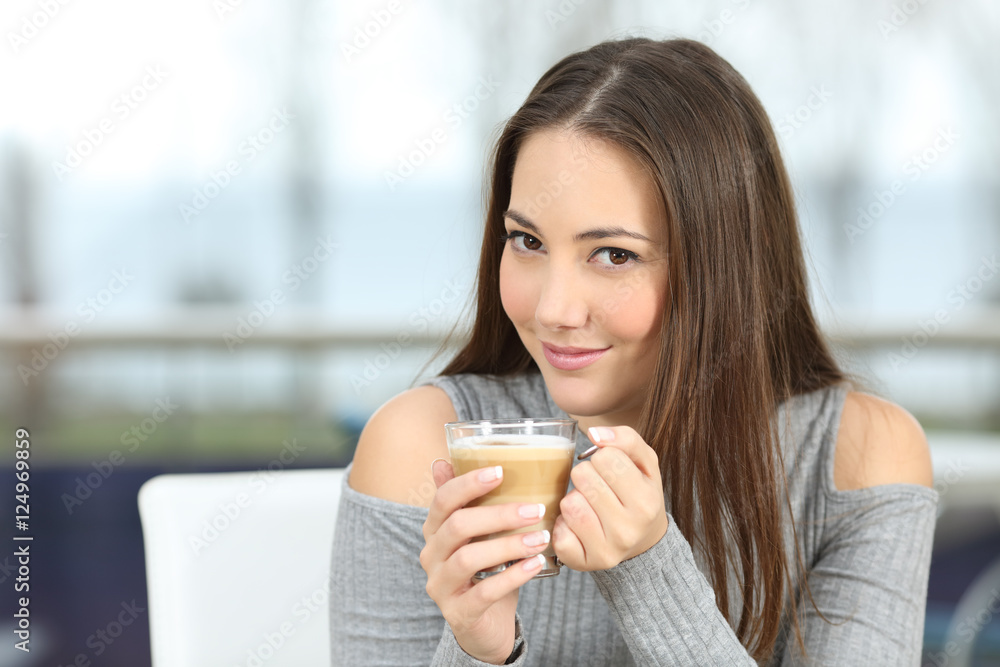 Confident woman posing holding a coffee cup Confident woman posing holding a coffee cup