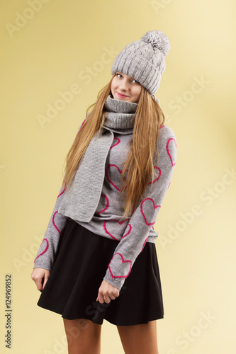 girl wearing gray woolen cap and scarf against yellow background photo