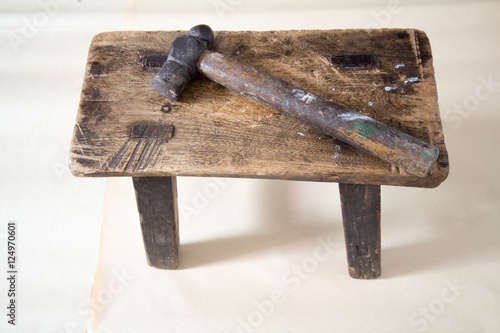 A vintage wooden chair and old a hammer. photo
