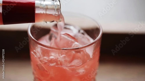 lemonade pouring from bottle to glass with ice