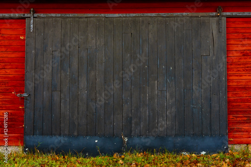 Fotografie Wooden black sliding door on red barn.