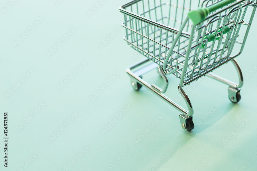 Empty shopping cart over the green background